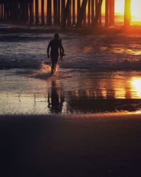 Silhouette man at beach during sunset
