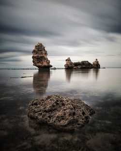 Rocks on sea shore against sky