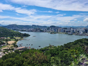 High angle view of townscape by sea against sky