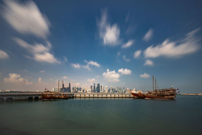 Sea by buildings against sky in city