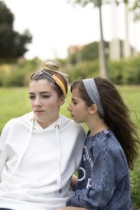 Close-up of siblings on field at park