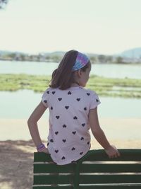 Rear view of girl standing against sea