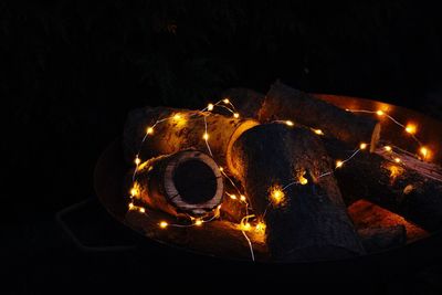 Low angle view of illuminated lighting equipment at night