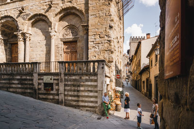 People on street amidst buildings in city