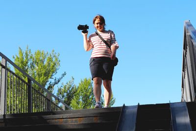 Photographer. the girl takes pictures standing on the bridge. high quality photo