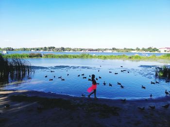 People on lake against sky