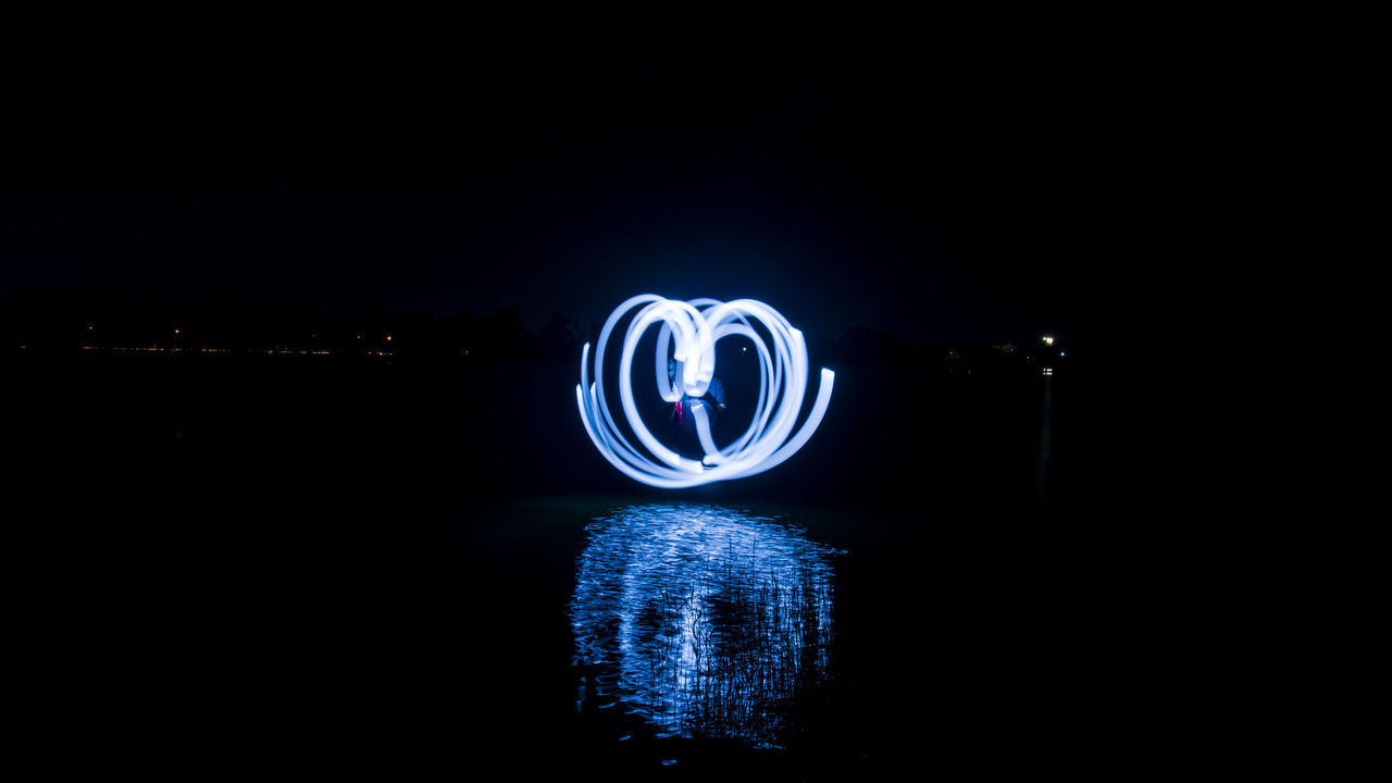 CLOSE-UP OF ILLUMINATED LIGHTING EQUIPMENT AGAINST BLACK BACKGROUND