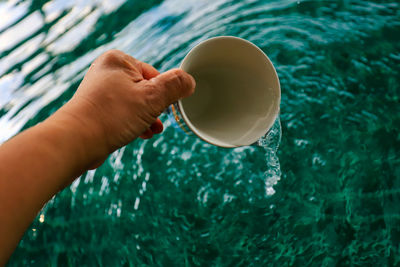 High angle view of hand holding ice cream in swimming pool