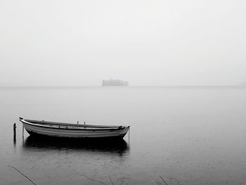 Boat in sea against sky during foggy weather