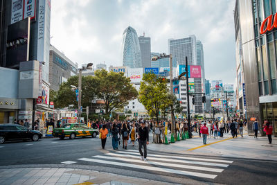 Crowded people are walking and shopping at a street in shinjuku town.