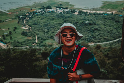 Portrait of smiling young man wearing sunglasses standing outdoors