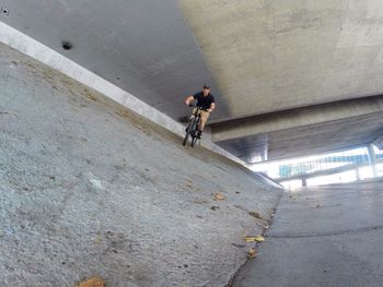 Low angle view of man riding bicycle on road