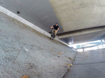 Low angle view of man riding bicycle on road