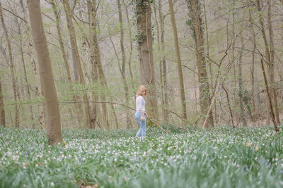 Full length of man standing on field in forest