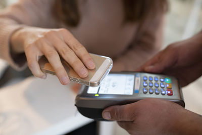 Woman paying through smart phone at restaurant