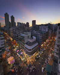 Aerial view of buildings in city against sky during sunset