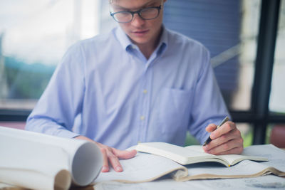 Close-up of man working on book