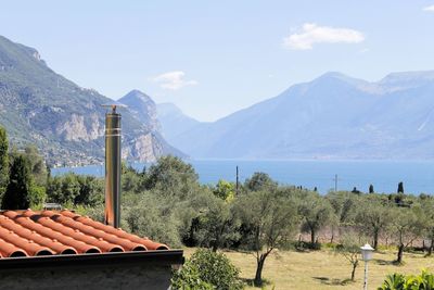 Scenic view of sea and mountains against sky