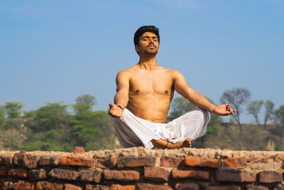 Portrait of young man standing against wall