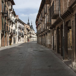 Empty road amidst buildings in city