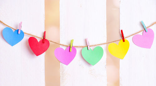 Close-up of multi colored heart shape hanging against wall