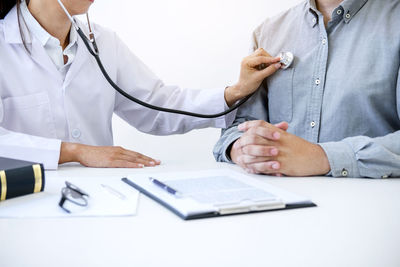 Midsection of female doctor examining patient in hospital