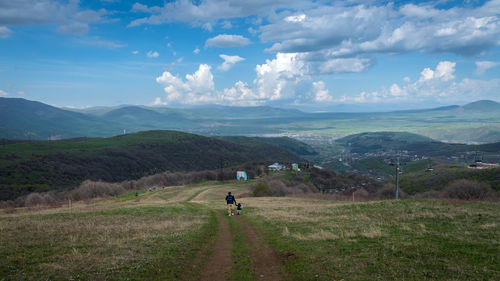 Scenic view of person riding motorcycle on field against sky