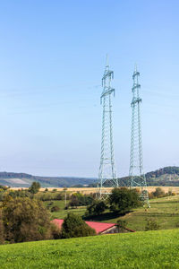 Electricity pylon on field against sky