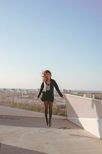 Woman levitating against clear sky