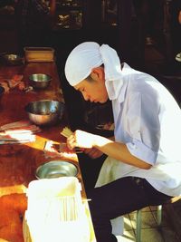 Side view of chef preparing food on table 