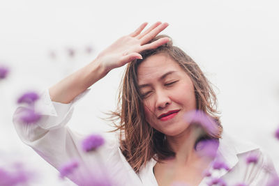 Low angle view of woman with eyes closed standing against clear sky