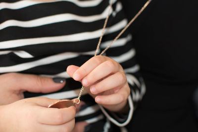 Midsection of girl holding necklace