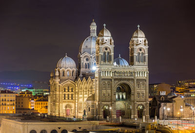 Illuminated buildings in city against sky at night