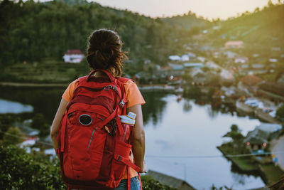 Rear view of woman with backpack looking at lake