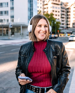 Portrait of young woman standing in city