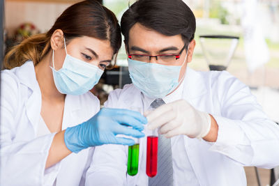 Man and woman examining test tubes in laboratory