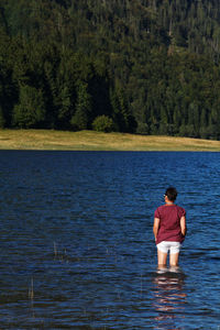 Rear view of woman standing in lake