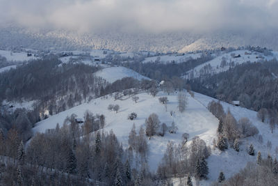 Panoramic view of snow covered landscape against sky