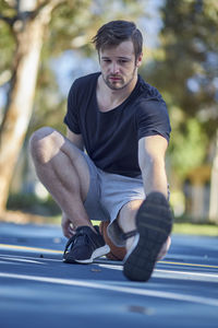 Full length of man stretching on footpath