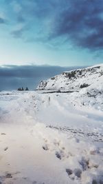Scenic view of snow covered beach against sky