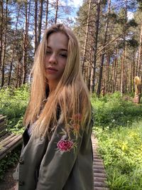 Beautiful young woman with tree trunk in forest