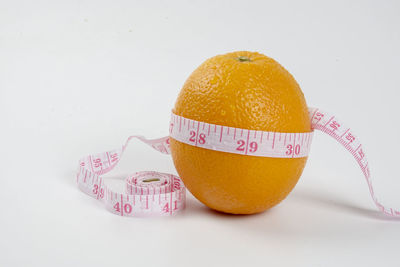 Close-up of orange fruit against white background