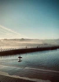 Scenic view of  surfer at sunrise 