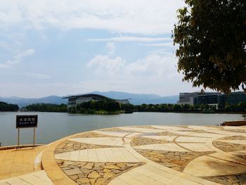 View of swimming pool by lake against sky