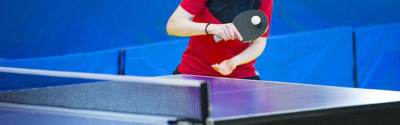 Midsection of player holding table tennis racket