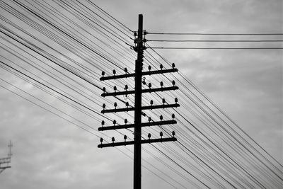 Low angle view of electricity pylon against sky