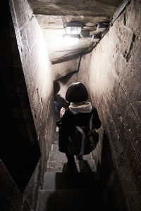 Rear view of woman walking in tunnel