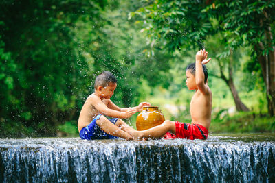 Shirtless boy sitting in water