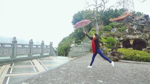 Woman with umbrella against clear sky