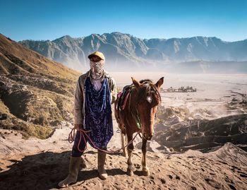 Portrait of man standing on mountain against sky